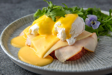 Sandwich with ham, cheese and herbs. Hearty, nutritious breakfast. Ready menu for the restaurant. Neutral gray blue textured background