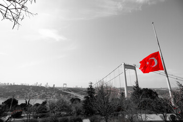 Half-staff Turkish Flag on the pole and monochrome cityscape of Istanbul