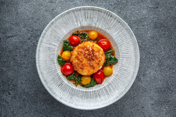 Chopped meat cutlet baked with cheese and grilled vegetables. Ready menu for the restaurant. Neutral gray blue textured background