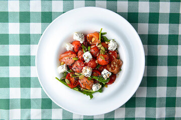 Tomato and salmon salad with cheese and spices. Traditional Italian cuisine, Italian concept.