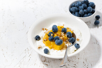 thick Greek yogurt with mango and blueberries
