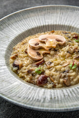 Risotto with wild mushrooms and champignons. Ready menu for the restaurant. Neutral gray blue textured background