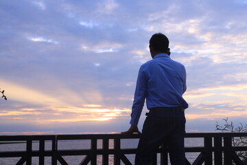 Fototapeta premium silhouette of a person standing on a pier and telephone.