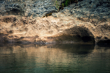 view on riverbank of small clear river forming a depression in the deposits