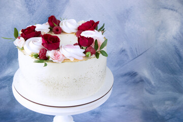 Modern  cake   with fresh red roses on white wooden cake stand, copy space . Concept for Wedding , St. Valentine's Day, Mother's Day, Birthday Cake.