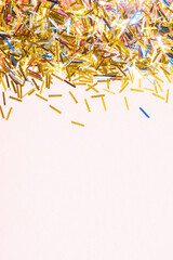 colorful tinsel confetti on a pink background