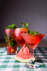 Water melon cocktails and fresh melon, on a table with green plaid tablecloth. Summer drink, cold beverage