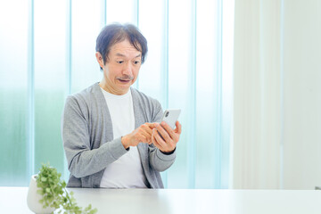 スマホを使う中高年男性（アプリ・驚く）
