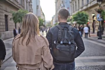 Fototapeta premium spring walk guy and girl back view, couple walks in the city seasonal view