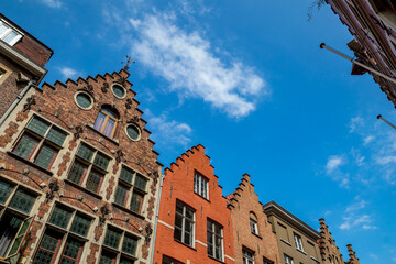 Low-angle perspective of the tops of the houses, street view of old Bruges, Belgium, cloudy summer day