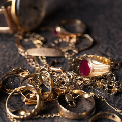We buy gold concept .Different  jewelry rings, chain, braclets, watch,  earrings on dark background.