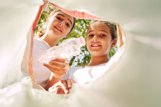 Cute Girls Putting Trash In A Garbage Bag