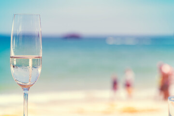 Glass of champagne on the beach.