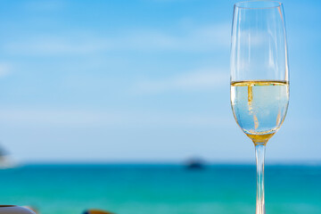Glass of champagne on the beach.