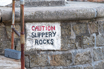 Caution Slippery Rocks sign on the Cornish coast