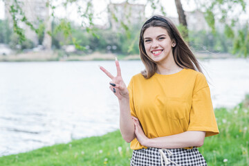 Portrait of a beautiful and young caucasian girl showing peace sign
