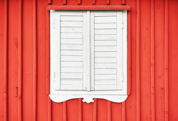 White wooden shutter on a red wall.