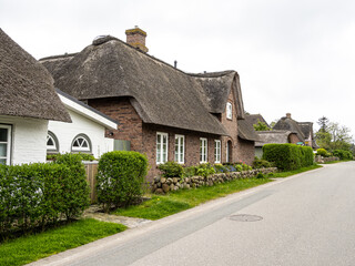 Fototapeta na wymiar Traditional Frisian thatched cottage in the village of Nebel on the island of Amrum, Germany