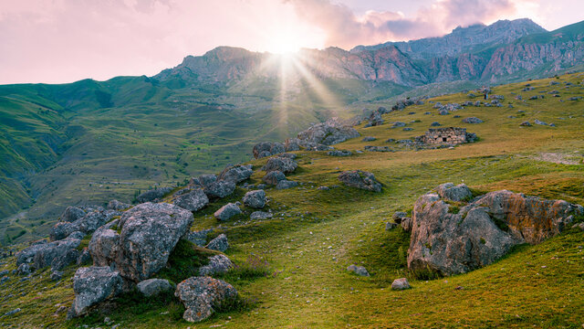 Sun rays breaking through the mountain at sunset.