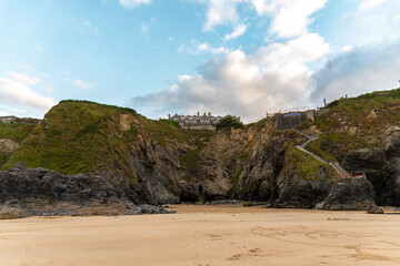 The rugged coastline of Newquay, Cornwall, with the Hotel Victoria perched on top of the cliff and the tunnel entrance to its life seen below