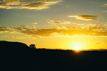 A landscape of rising savanna sunrises with gradations in the sky (Masai Mara National Reserve,...