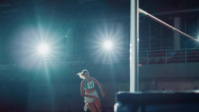 High Jump Championship: Professional Female Athlete Running and Successfully Jumping over Bar. Determination, Motivation, Effort of a True Champion. Cinematic Light, Dolly Pan Slow Motion Shot