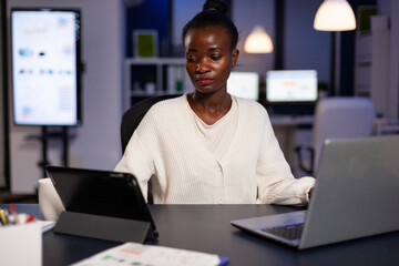 Workaholic tired multitasking african american entrepreneur analyzing financial graphs on computer...