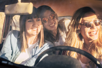 Three cheerful female friends traveling in car. Girl friends having fun while enjoying car journey...