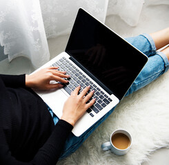 Woman sitting on the floor and using laptop