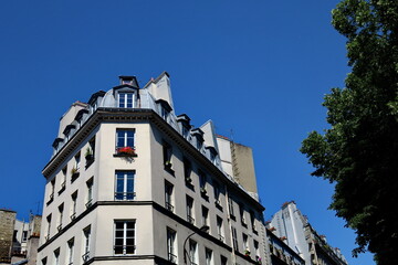Derniers étages d'un vieil immeuble. Ciel bleu. Paris.