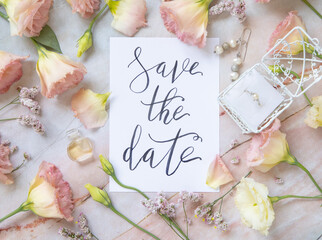 Card with the text SAVE THE DATE surrounded by pink flowers
