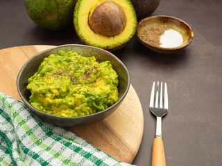 Guacamole and guacamole ingredients on vintage background. Top view, copy space. Concept of traditional Mexican preparation