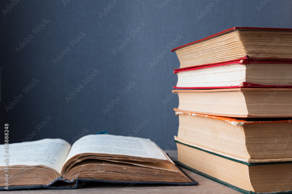 Poster stack of books lies on table, one of them is open. with copy space. background concept on education,