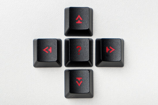 Close-up view of black computer arrow keys showing four opposite directions and a question mark on the center button. The concept of finding the right solution