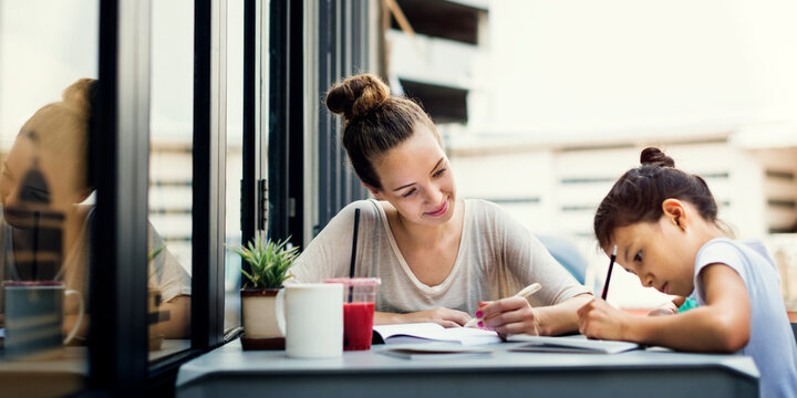 Girl with a tutor doing homework outside