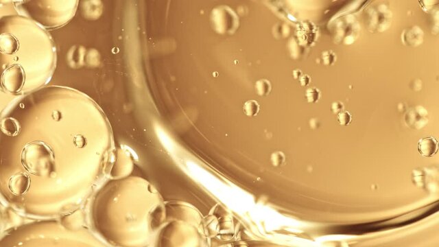 Super Slow Motion Shot of Moving Oil Bubbles on Golden Background at 1000fps.