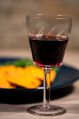 glass of red wine in front of a plate of ravioli