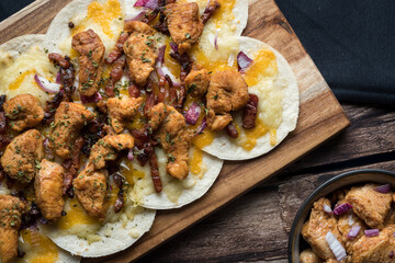 Overview of homemade taco-pizza with chicken, cheese and onion with low key composition