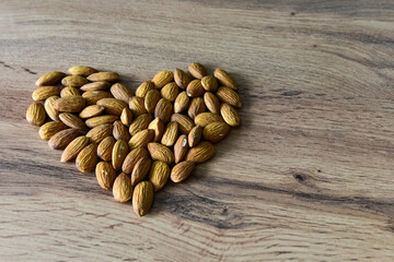 Almonds lying on the table in the form of a heart. Copy space