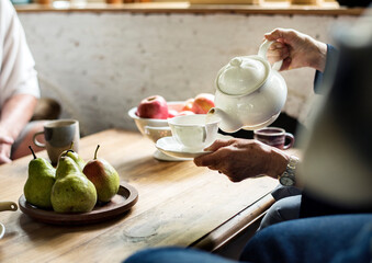 Serene scene of a hand pouring tea in a cup, tea time