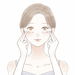 目の下をマッサージする女性