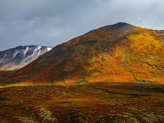 Dramatic golden light and shadow on the rock in autumn steppe. High-altitude plateau of Yeshtykol. Altai Mountains