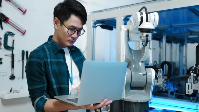 Asian Engineers Maintenance Robot Arm at Lab. they are in a High Tech Research Laboratory with Modern Equipment. Technology and Innovation Concept.Professional Japanese Development Engineer.