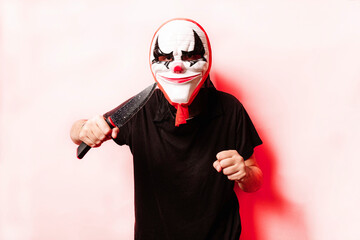 Woman in a halloween mask threatening with a knife, on colored background. Halloween concept.