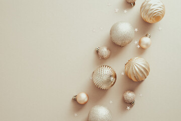 Christmas and New Year holidays concept with golden balls decorations on pastel beige background....