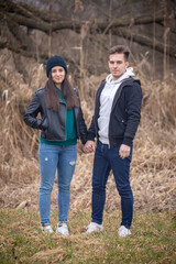 Naklejka na ściany i meble Young couple standing in nature on a winter day