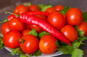 Fresh tomatoes hot peppers and selera greens in drops of water on a plate, tasty and healthy vegetables, selective focus	