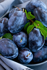 Fresh raw blue plums on the table, monochromatic color image