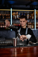 Barman puts the ice cubes into a glass