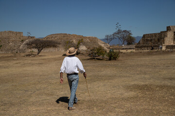 Fototapeta na wymiar A man in a hat walks through an ancient city in Mexico. 